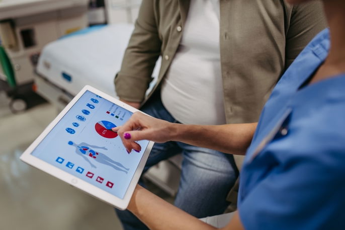 Persona con sobrepeso en consulta con una doctora